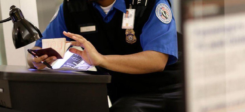 A TSA agent checks a passport at Baltimore Washington Airport.
