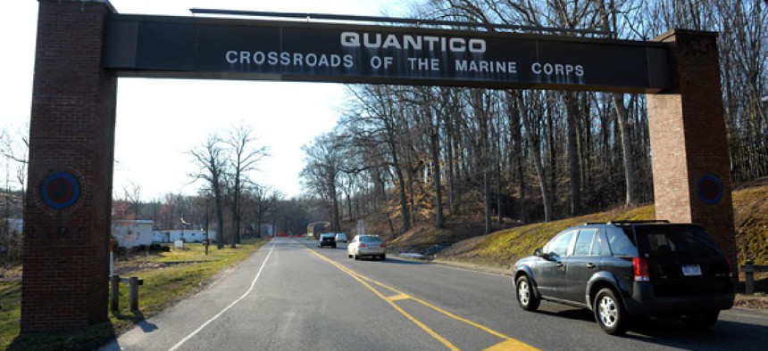 Cars pass under a sign at the entrance to the main gate at Quantico Marine Corps Base in Quantico, Va.