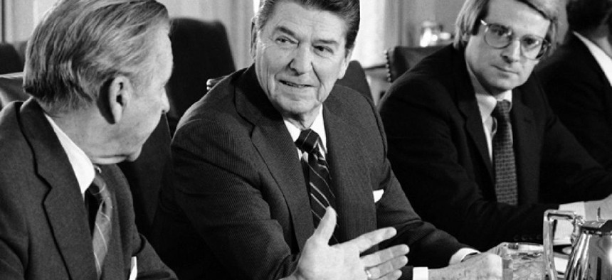 President Ronald Reagan talks with Treasury Secretary Donald Regan, left, while office of Management and Budget Director David Stockman looks on in the Cabinet Room of the White House, Monday, Jan. 28, 1985.