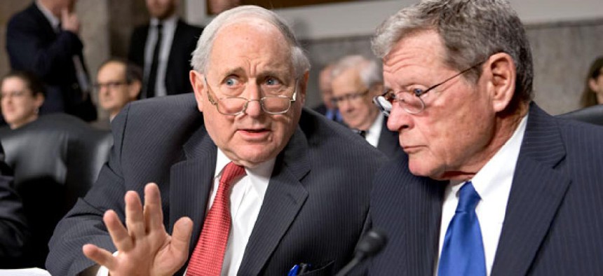 Senate Armed Services Committee Chairman Sen. Carl Levin, D-Mich., left, talks with the committee's ranking Republican, Sen. James Inhofe, R-Okla.