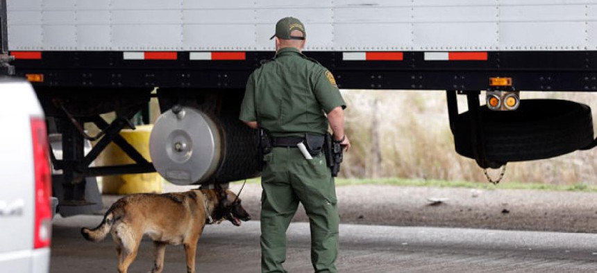 A Customs and Border Patrol agent and a security dog keep watch at a checkpoint in Falfurrias, Texas.