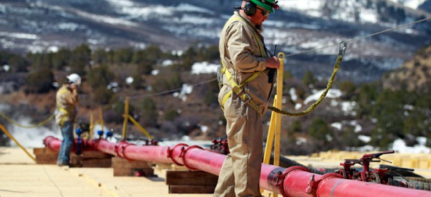 A worker helps monitor water pumping pressure and temperature, at the site of a natural gas hydraulic fracturing and extraction operation in western Colorado.
