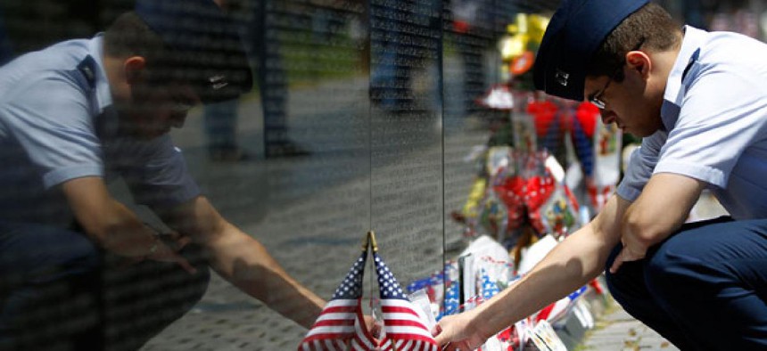 A visitor looks at items left at the Vietnam Veterans Memorial, ahead of Memorial Day in Washington, Sunday, May 26, 2013.