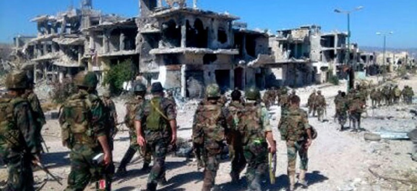 Syrian soldiers loyal to President Bashar Assad in the town of Qusair patrol in early June.