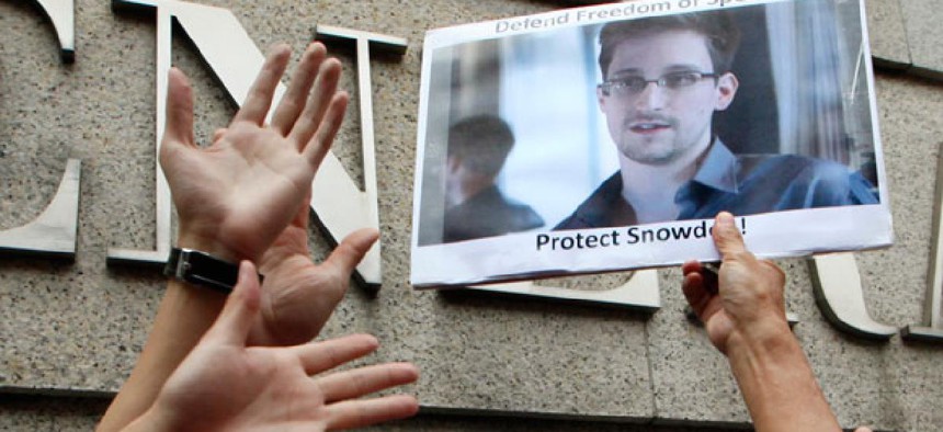 Protestors outside of the U.S. consulate in Hong Kong hold up a photo of Edward Snowden.