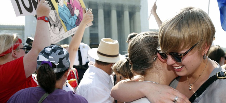 American University students Sharon Burk, left, and Molly Wagner, embrace outside the Supreme Court in Washington.