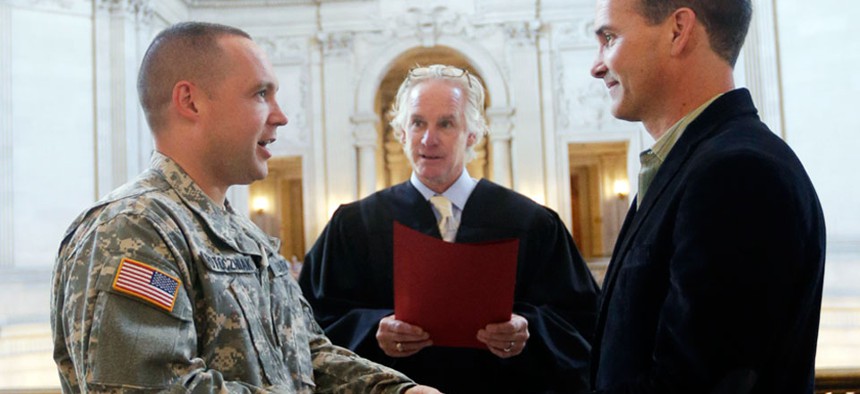 Army Capt. Michael Potoczniak, left, and Todd Saunders are married by deputy marriage commissioner John Loschmann at San Francisco City Hall.