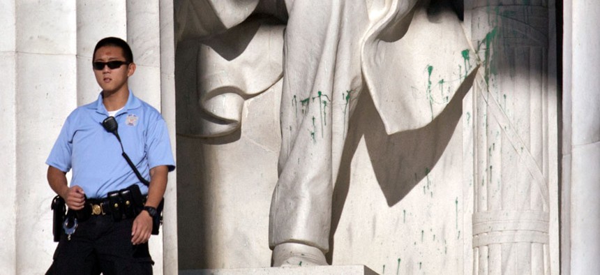 A U.S. Park Police officer stands guard next to the statue of Abraham Lincoln after it had been vandalized. 
