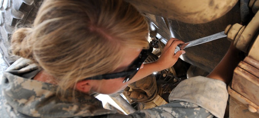 A mechanic works on an armored vehicle in Iraq in 2011.