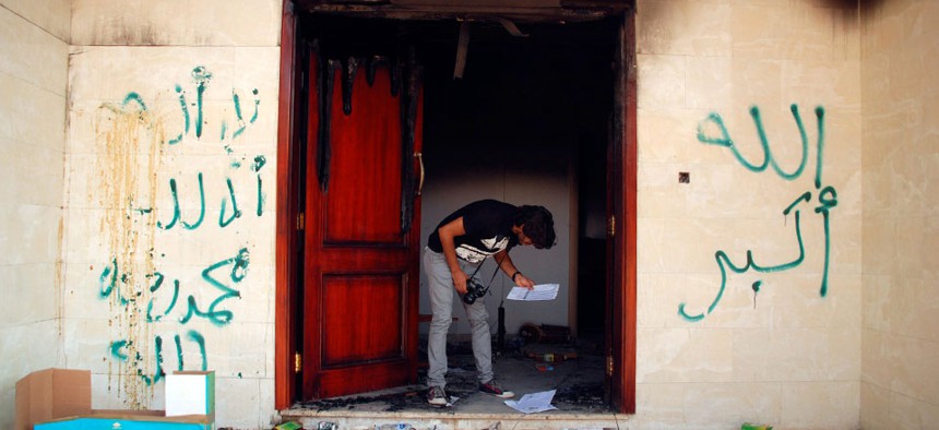 A man looks at documents at the U.S. consulate in Benghazi, Libya, after an attack that killed four Americans, Sept. 12, 2012. 