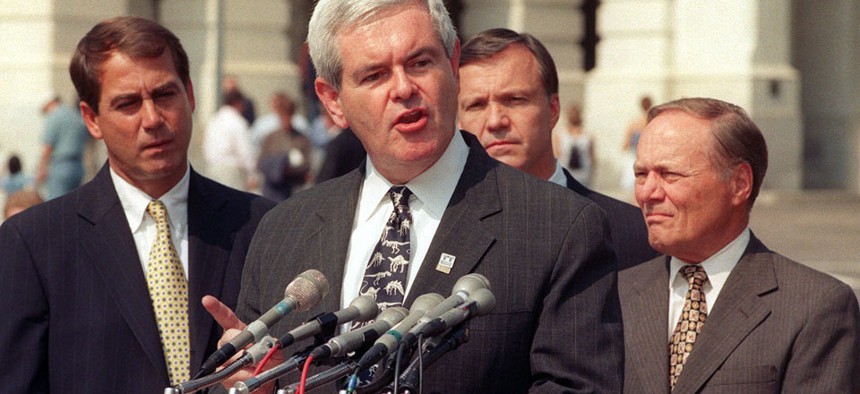 John Boehner looks over the shoulder of then-House Speaker Newt Gingrich at a 1998 press conference. 