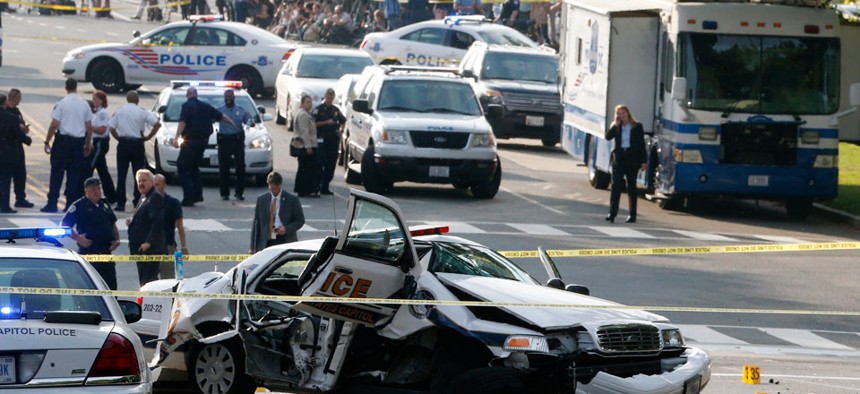 A wrecked Capitol Police car blocks Constitution Avenue NW following a shooting on Capitol Hill in Washington.