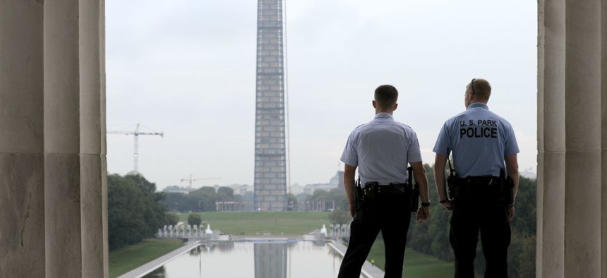 With the Washington Monument in the distance, Park Service police officers stand on duty at the Lincoln Memorial.