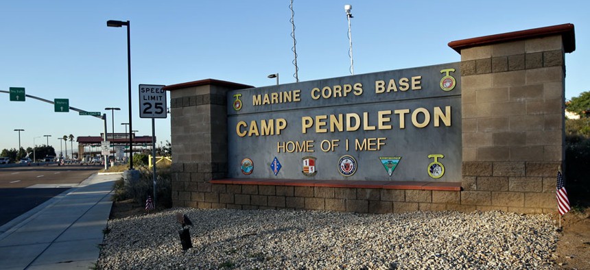 Vehicles file through the main gate of Camp Pendleton Marine Base on Wednesday, Nov. 13, 2013.