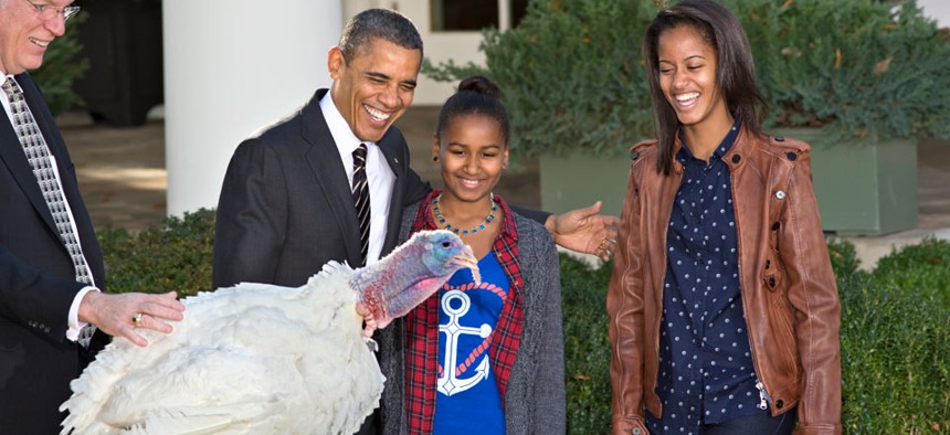 Barack Obama and his daughters participate in a turkey pardoning ceremony in 2012.