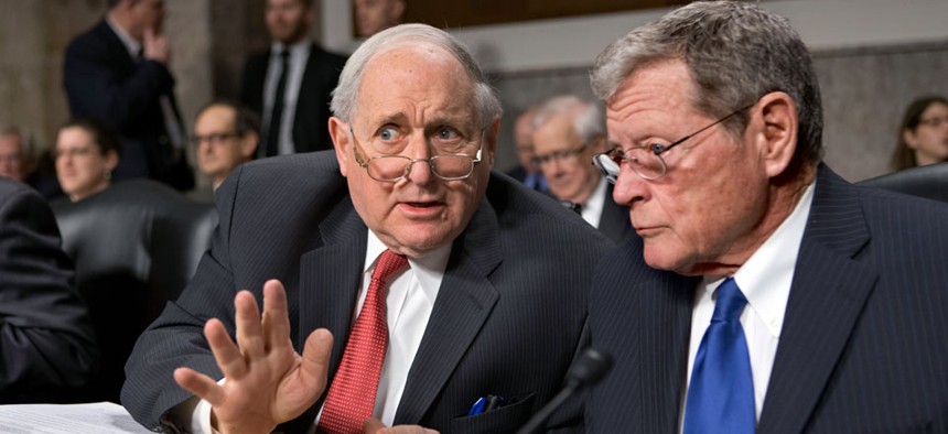 Senate Armed Services Committee Chairman Sen. Carl Levin, D-Mich., left, talks with the committee's ranking Republican, Sen. James Inhofe, R-Okla.