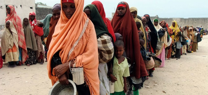Somali women and children from southern Mogadishu, line up to receive food at a camp in Mogadishu. 
