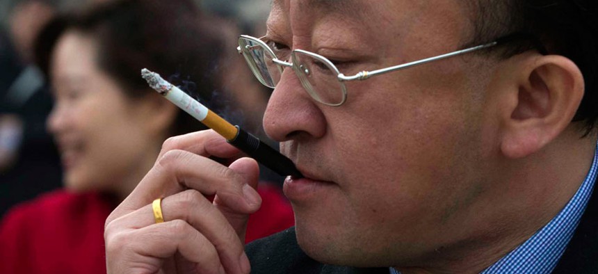A delegate smokes as he leaves a pre-opening session of the Chinese People's Political Consultative Conference in Beijing in March.