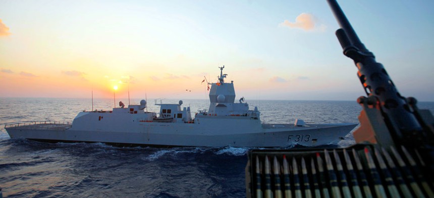The Norwegian warship "Helge Ingstad" passes by the Danish warship Esbern Snare during a sunset at sea between Cyprus and Syria, Sunday, Jan. 5, 2014.