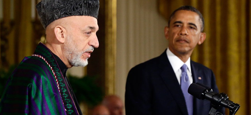 President Barack Obama listens as Afghan President Hamid Karzai speaks during a news conference.