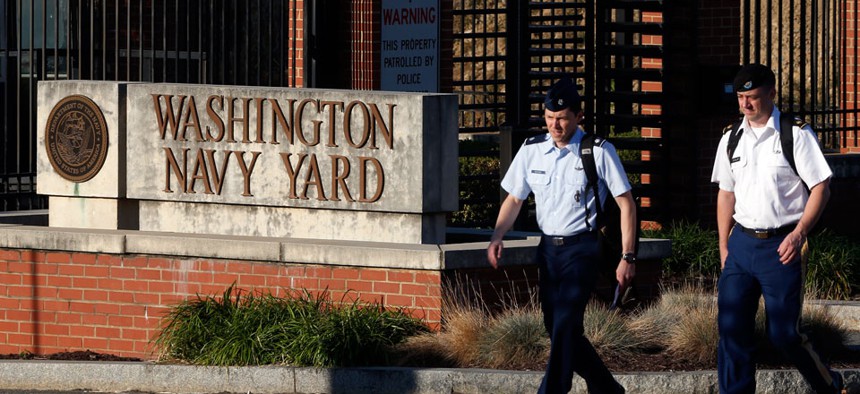 Military personnel walk past an entrance to the Washington Navy Yard Thursday, Sept. 19, 2013.
