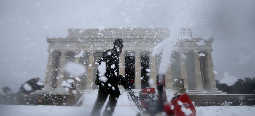 A Park Service employee clears snow Thursday on the grounds of the Lincoln Memorial.