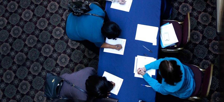 Job seekers line up to sign in before meeting prospective employers at a career fair in Dallas. 