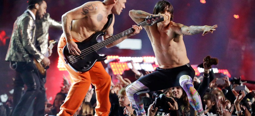 The Red Hot Chili Peppers band members Flea, center, and Anthony Kiedis perform during the halftime show of the NFL Super Bowl XLVIII. 