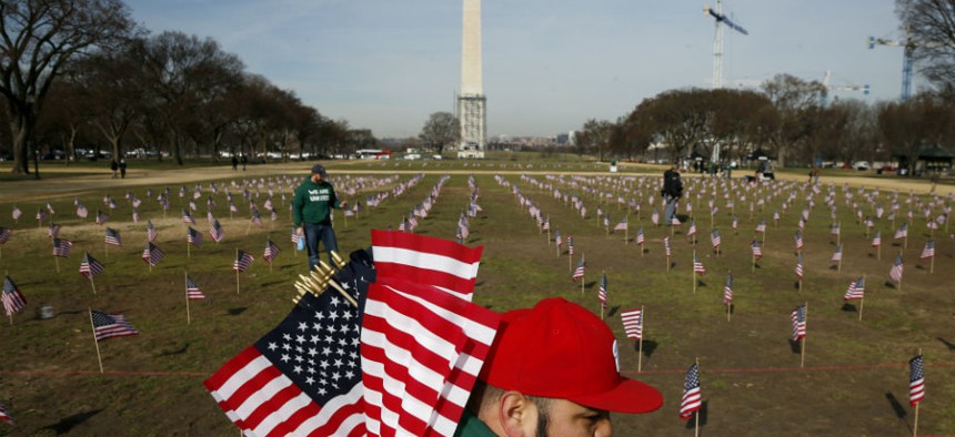 Army veteran Julio Bernal works with others from Iraq and Afghanistan Veterans of America to place 1,892 flags representing veteran and service members who have died by suicide to date in 2014 on the National Mall in Washington.