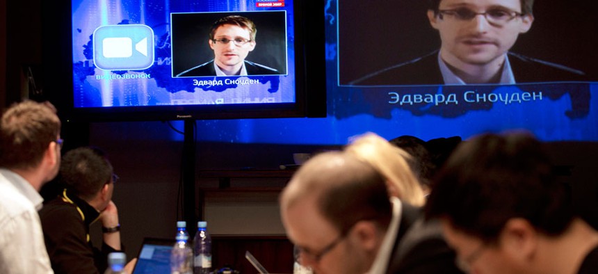 Edward Snowden, displayed on television screens, asks a question to Russian President Vladimir Putin during a nationally televised question-and-answer session, in Moscow.
