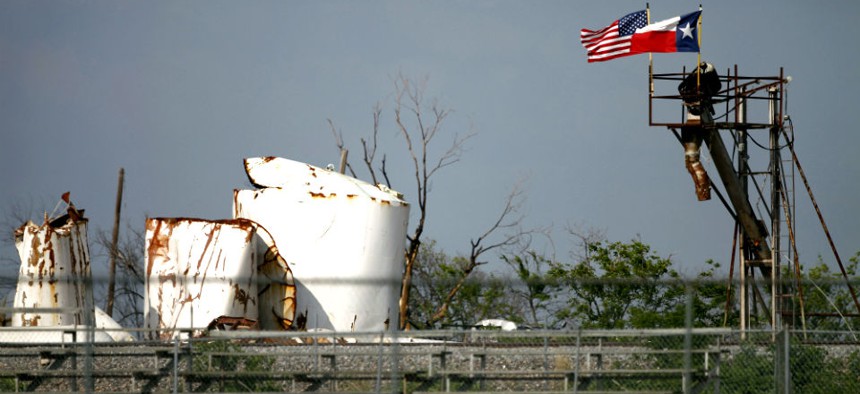 An American and Texas flag fly side by side Friday, May 31, 2013, in West, Texas, atop the destroyed remains of the fertilizer plant that exploded killing 15 and injuring 200.