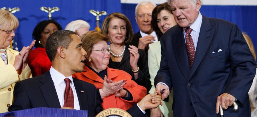 President Barack Obama hands Sen. Edward Kennedy, D-Mass., the first pen as he signs the Edward M. Kennedy Serve America Act, Tuesday, April 21, 2009.