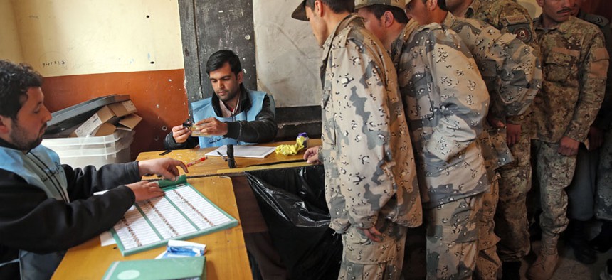 Afghan security personnel line up for the registration process before they cast their votes at a polling station in Kabul, Afghanistan, Saturday, April 5, 2014.