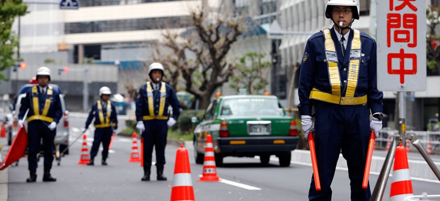 Policemen stand in front of the U.S. Embassy in Tokyo, Tuesday, April 22, 2014. Security has been increased in the Tokyo metro area a day before U.S. President Barack Obama arrives.