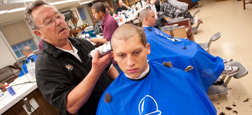 Bill Maynard cuts the hair of Jordan Converse at the U.S. Coast Guard Academy in 2012.