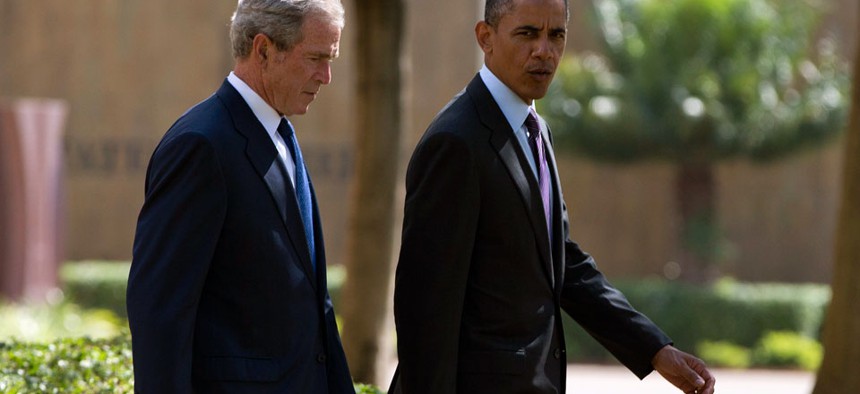U.S. President Barack Obama, right, walks with former president George W. Bush. 