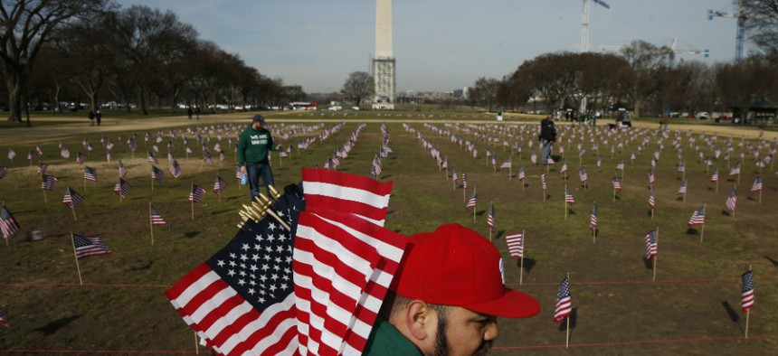 Army veteran Julio Bernal, works with others from Iraq and Afghanistan Veterans of America to place 1,892 flags representing veteran and service members who have died by suicide to date in 2014 on the National Mall.