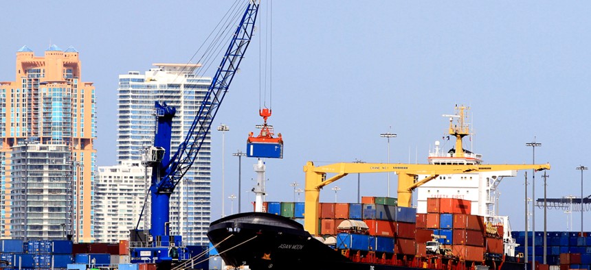 a crane prepares to load a container onto the cargo ship Asian Moon in the Port of Miami. 
