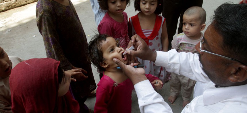A Pakistani health worker gives an oral polio vaccine to a child in Lahore, Pakistan.