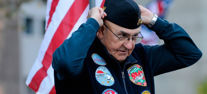 Submarine veteran Lawrence Check adjusts his hat before watching a parade on Veterans Day in Atlanta in 2012.