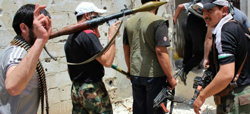 Syrian rebels hold their weapons as they prepare to fight against Syrian troops, in Homs province, Syria. 