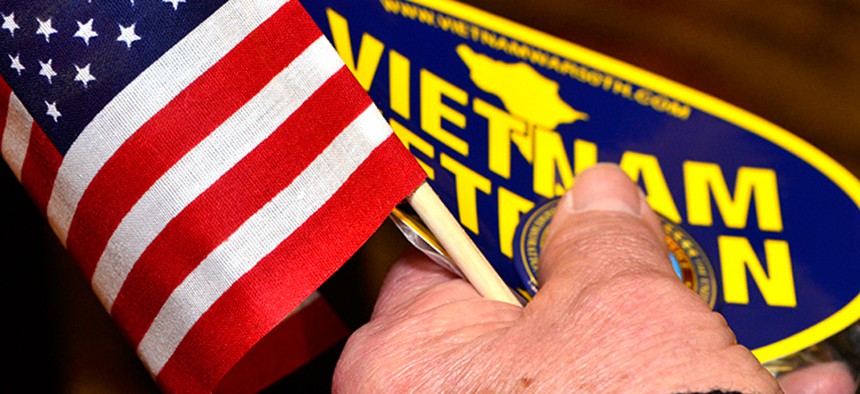 A veteran holds a sticker and a flag at a VA event in South Carolina in February.