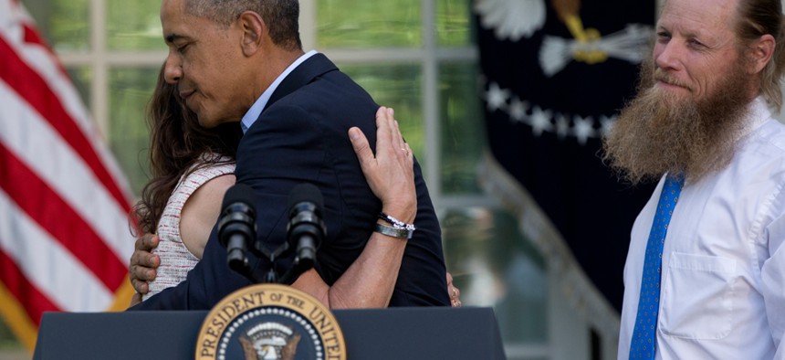 Obama hugs Jani Bergdahl, as Bob Bergdahl stands nearby on May 31.