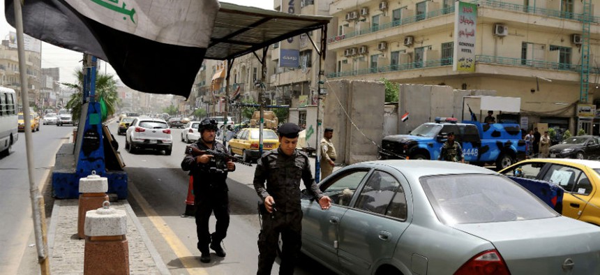 Iraqi federal policemen stand guard at a checkpoint in Baghdad, Iraq, Wednesday, June. 11, 2014. 