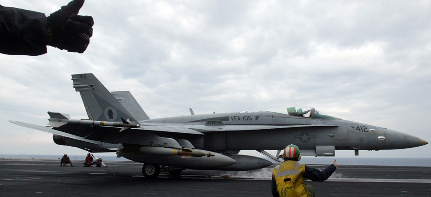 Final checkers give thumbs up to an F/A-18 Hornet on the flight deck of the U.S.S. Harry S. Truman in preparation for a strike operation in Iraq in 2003.