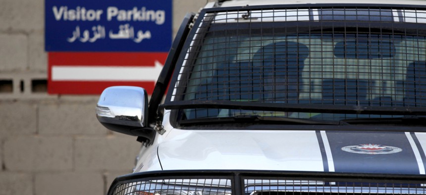 A Bahraini police officer sits in a police car at a new checkpoint near the U.S. Embassy in Manama, Bahrain, in 2013.