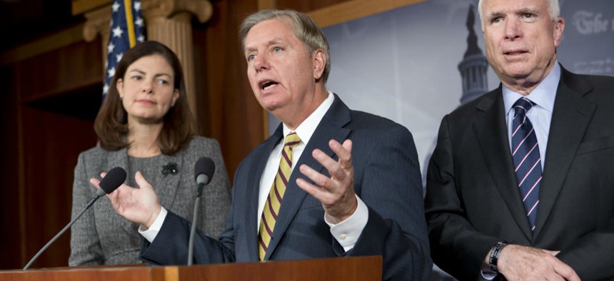 Sen. John McCain, R-Ariz., right, the ranking member of the Senate Armed Services Committee, right, joined by Sen. Lindsey Graham, R-S.C., center, and joined by Sen. Kelly Ayotte, R-N.H., left,