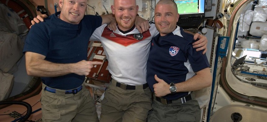 Astronauts Steve Swanson, Alexander Gerst, and Reid Wiseman smile after Gerst shaved the Americans' heads.