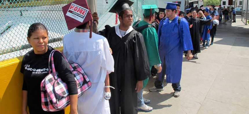 Wearing graduation-style caps and gowns, U.S.-raised immigrants wait on the Mexican side of the international bridge as they try to return to the U.S. from Nuevo Laredo, Mexico in September.