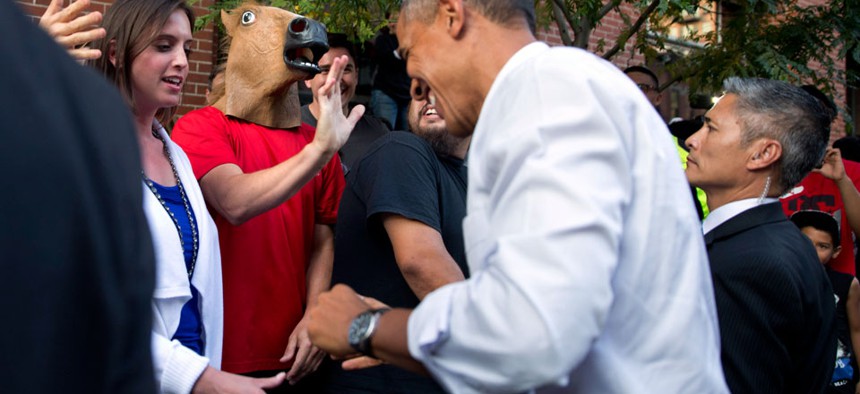 President Barack Obama laughs as he spots a man wearing a horse-head mask during an impromptu walk down a street in Denver.